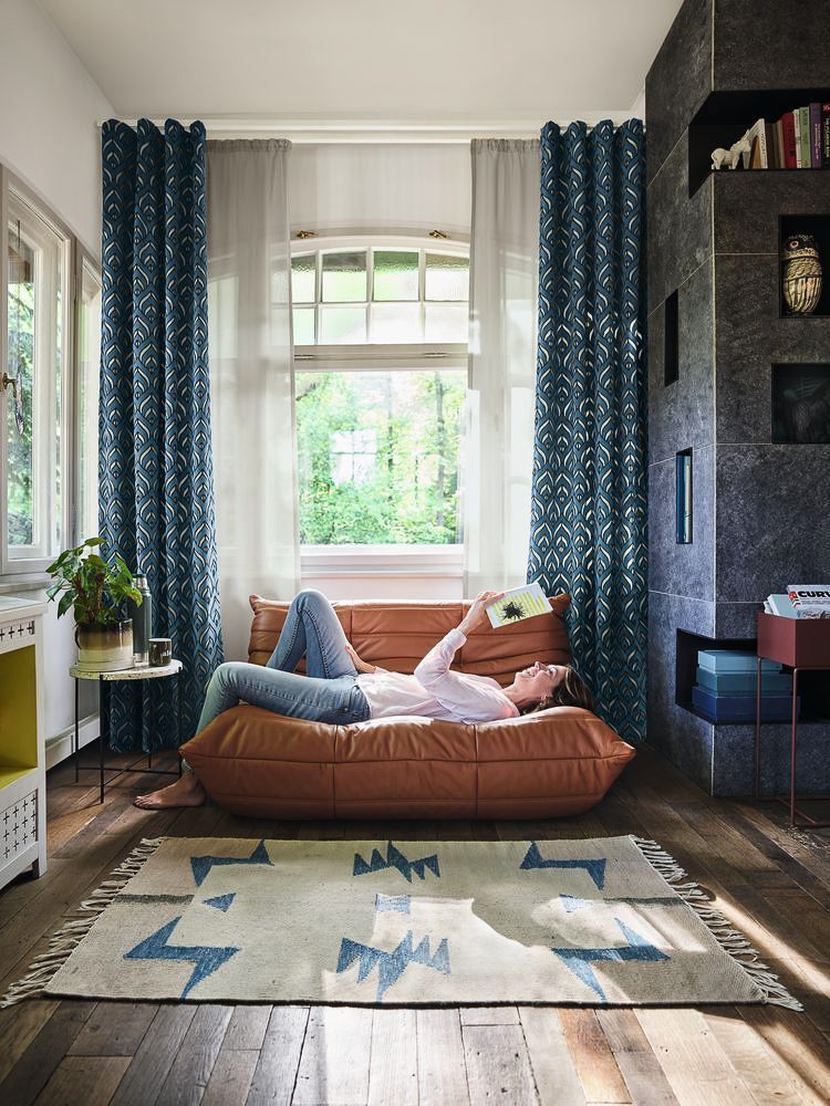 Ein Mann liegt auf einer Couch und liest ein Buch - Gardinen von Koke Raumausstattung - Tobias Liebrand - vor Ort in Senden und Lüdinghausen