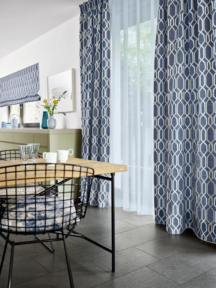 ein Esszimmer mit einem Tisch und Stühlen und blauen Vorhängen - Gardinen von Koke Raumausstattung - Tobias Liebrand - vor Ort in Senden und Lüdinghausen