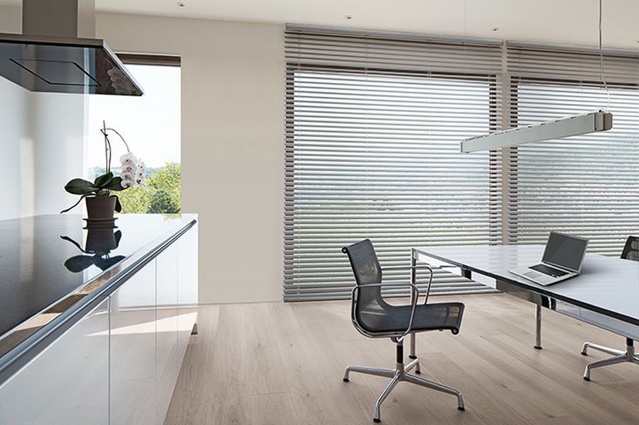 ein Raum mit einem Tisch und Stühlen und einem Laptop auf dem Tisch - Sonnenschutz von Koke Raumausstattung - Tobias Liebrand - vor Ort in Senden und Lüdinghausen