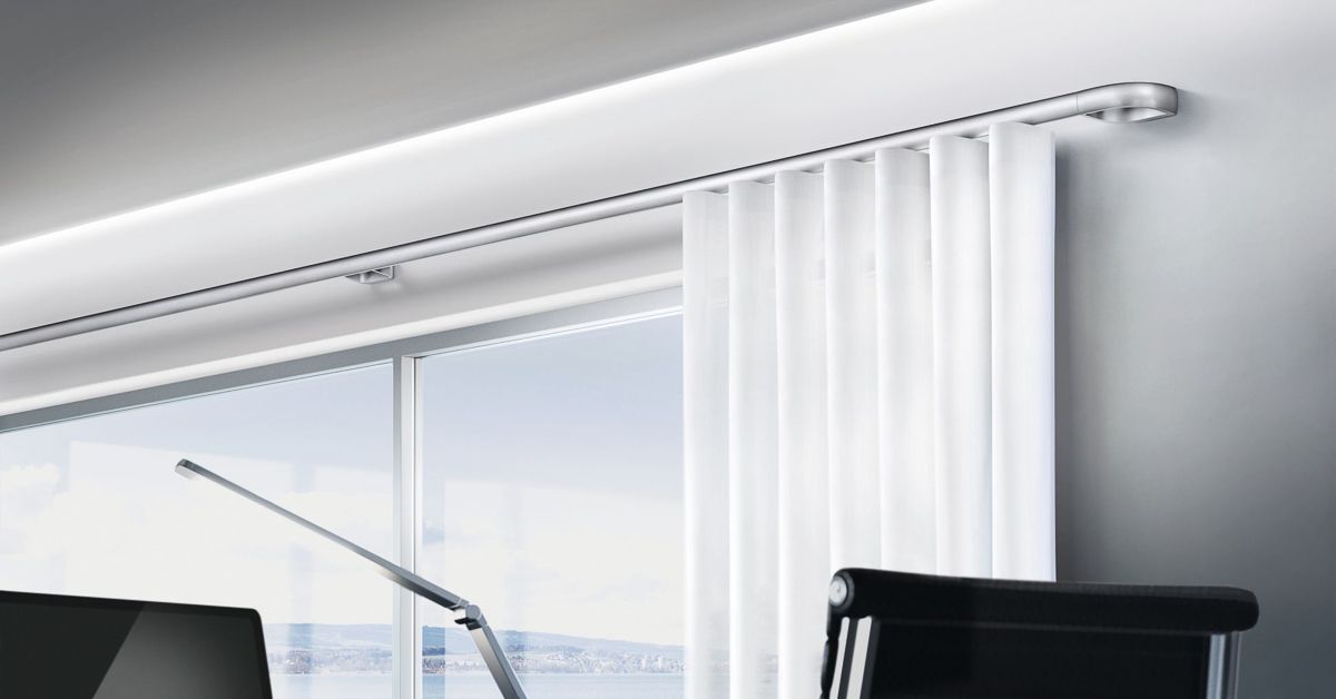 ein Wohnzimmer mit weißen Vorhängen , einem Stuhl , einer Lampe und einem großen Fenster - Gardinen von Koke Raumausstattung - Tobias Liebrand - vor Ort in Senden und Lüdinghausen