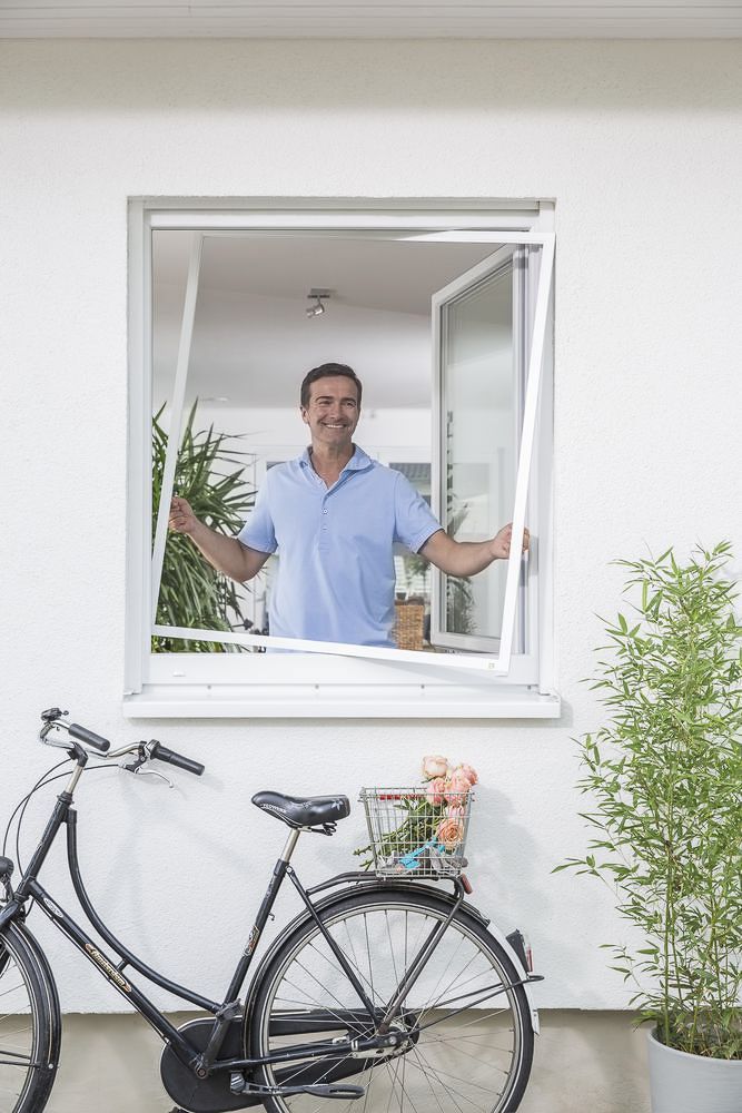 ein mann steht vor einem fenster mit einem fahrrad davor - Insektenschutz von Koke Raumausstattung - Tobias Liebrand - vor Ort in Senden und Lüdinghausen
