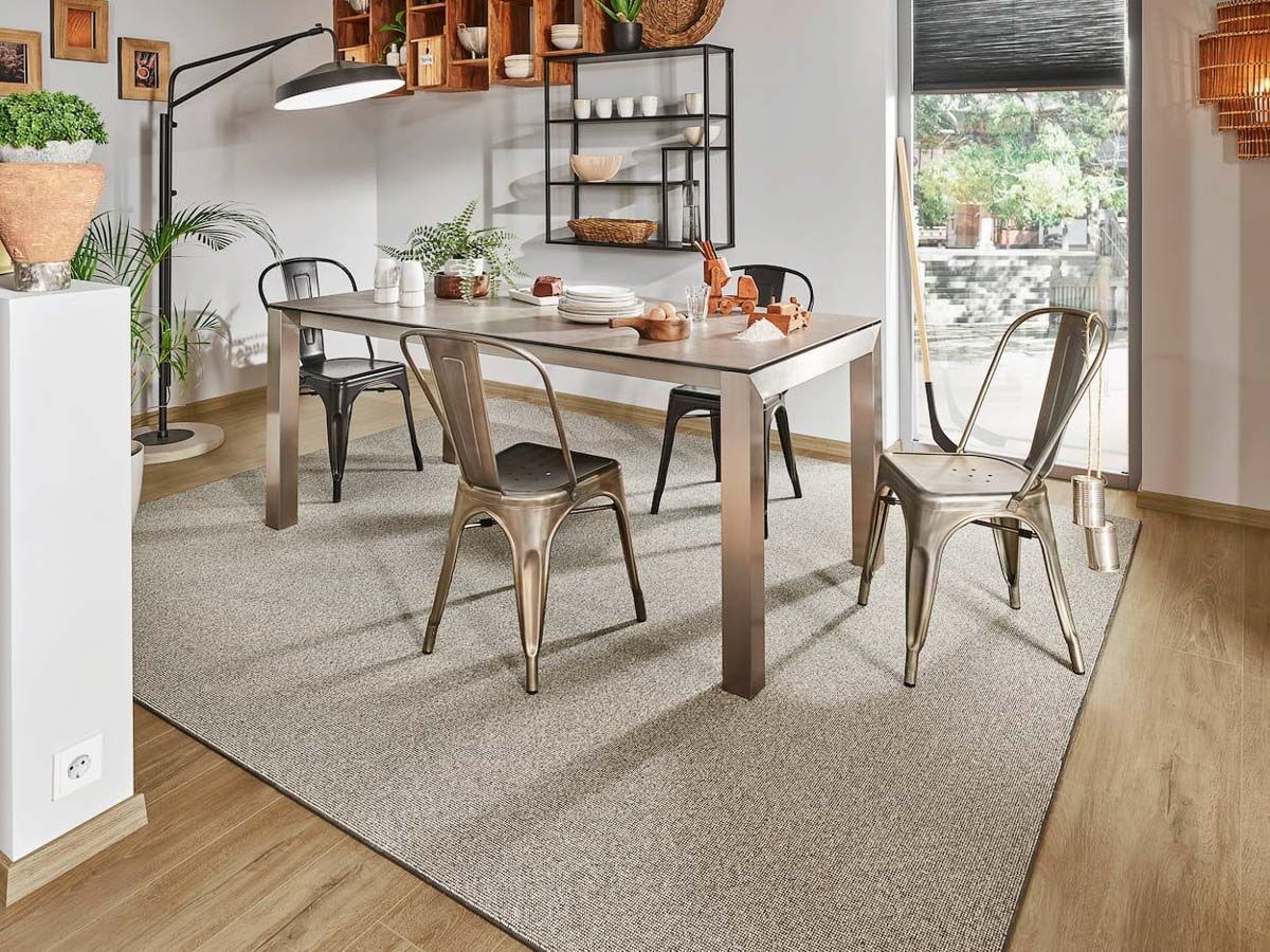 ein Esszimmer mit einem Tisch und Stühlen und einem Teppich - Bodenbeläge von Koke Raumausstattung in Senden und Lüdinghausen