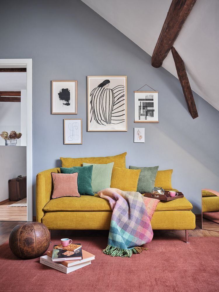 ein Wohnzimmer mit einer gelben Couch und einer bunten Decke - Polsterei von Koke Raumausstattung - Tobias Liebrand - vor Ort in Senden und Lüdinghausen