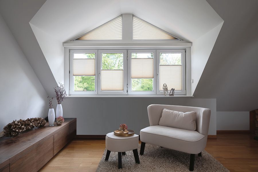 ein Wohnzimmer mit einem Stuhl , einem Tisch und einem Fenster - Sonnenschutz von Koke Raumausstattung - Tobias Liebrand - vor Ort in Senden und Lüdinghausen