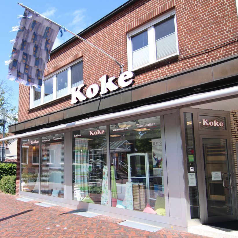 ein Backsteingebäude mit einem großen Schaufenster und einem Schild mit der Aufschrift koke - Standorte der Koke Raumausstattung - Tobias Liebrand - vor Ort in Senden und Lüdinghausen