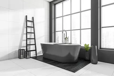 Baño moderno con bañera gris, ventana grande y escalera negra. Azulejos blancos y detalles oscuros.