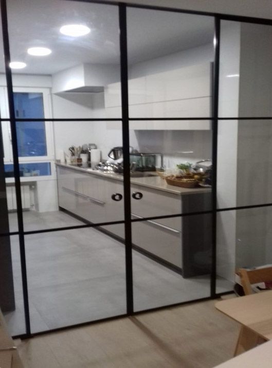 Una cocina con una puerta corrediza de vidrio entre la cocina y la sala de estar.