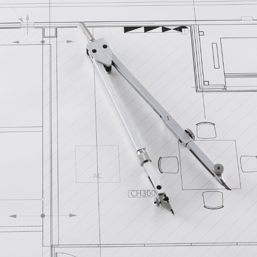 Una brújula descansa sobre un plano arquitectónico, resaltando un diseño detallado con líneas y formas.