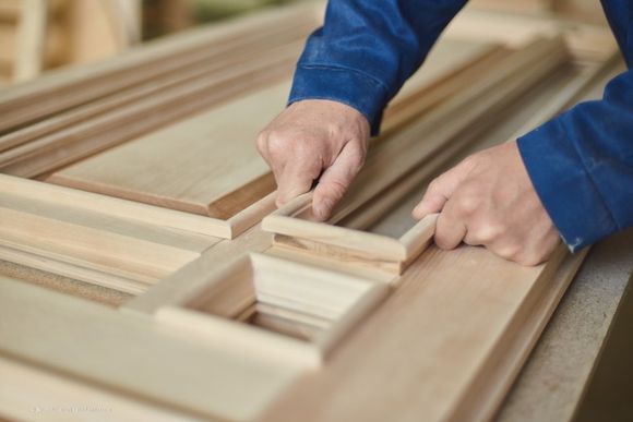 Schreiner der Schreinerei Liebl GmbH stellt Tür aus Holz her