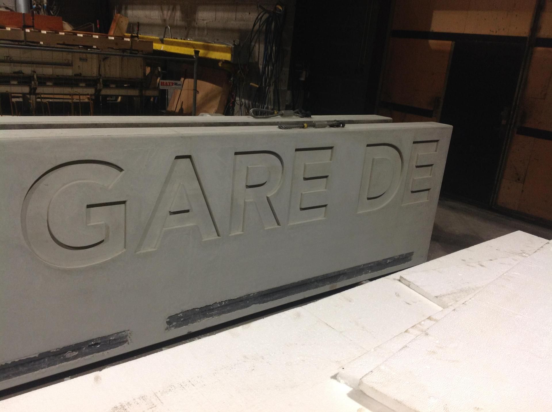 Panneau de gare en béton avec texte en négatif