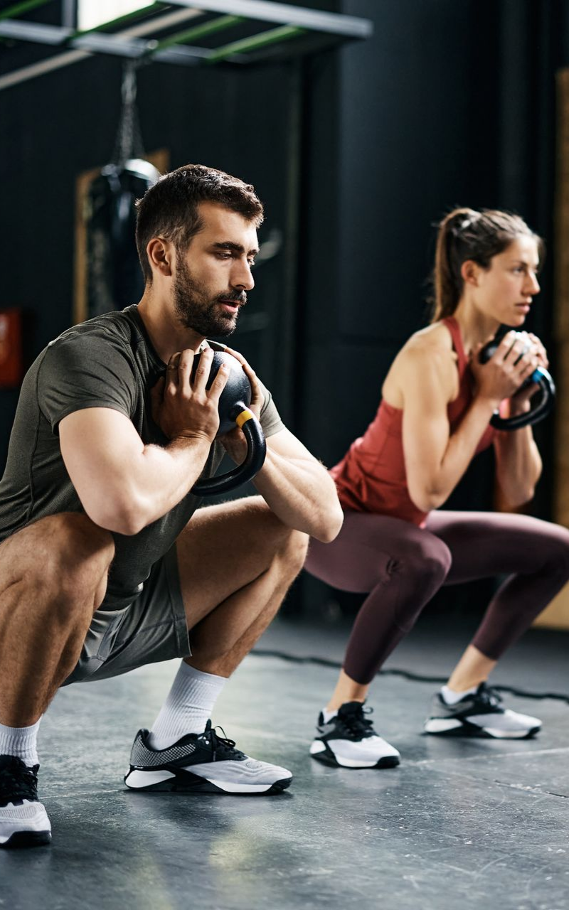 Un homme et une femme font des squats.
