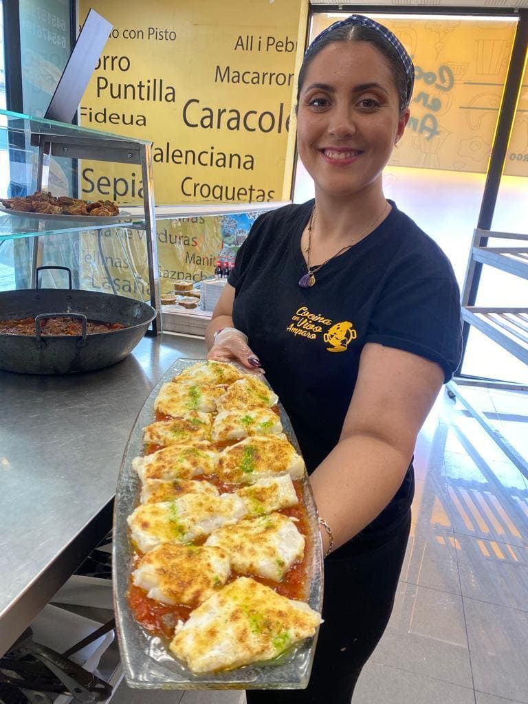 Una mujer sostiene un plato de comida en un restaurante.