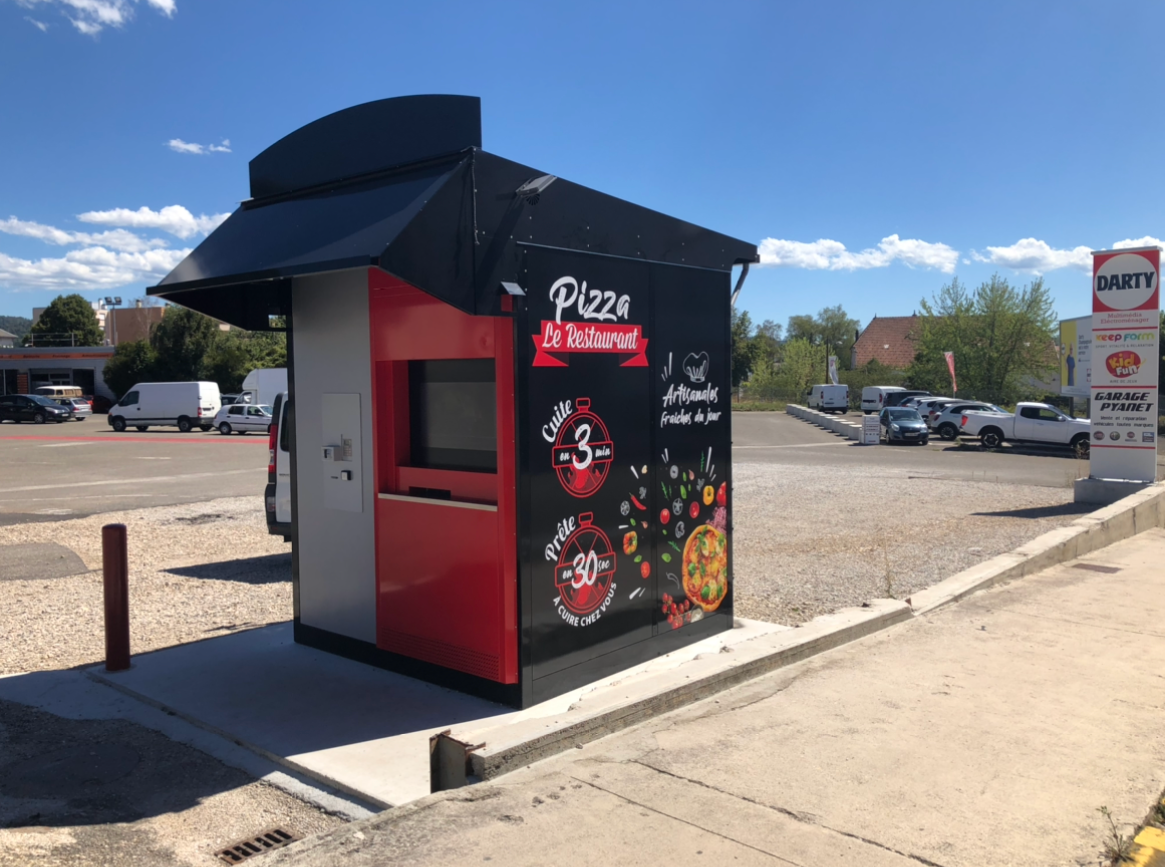 Photo d'un distributeur à pizzas sur un parking