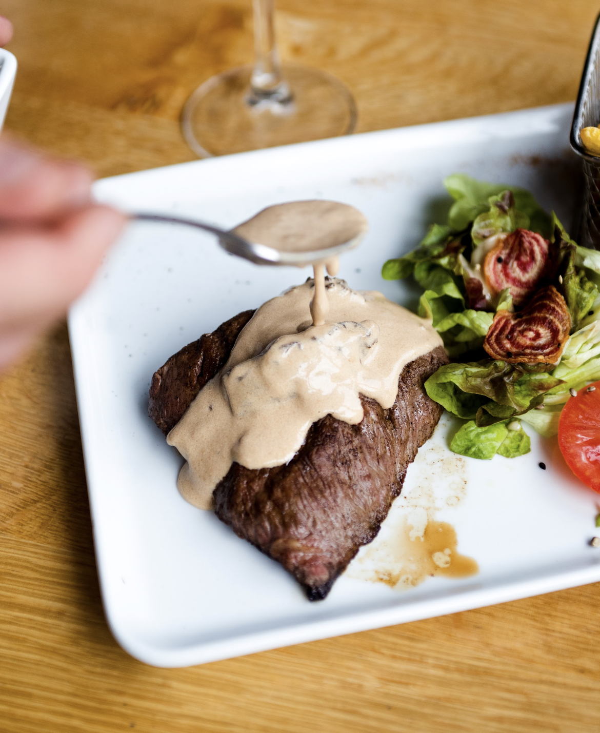 Pavé de bœuf avec une sauce par dessus et de la salade