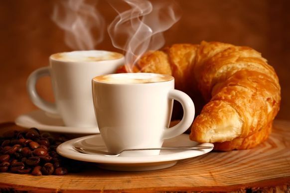Zwei Tassen Cappuccino und ein Croissant