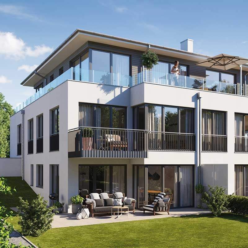 Ein großes weißes Haus mit vielen Fenstern und einem Balkon.