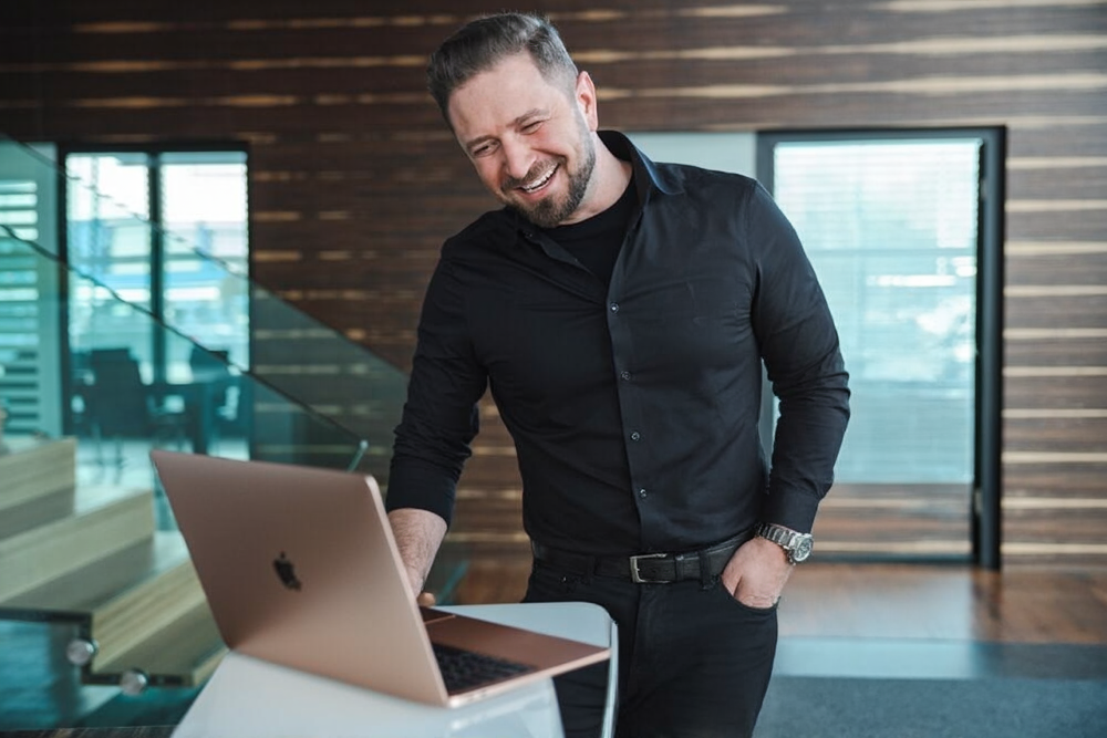 Ein Mann und eine Frau schauen sich einen Laptop an.