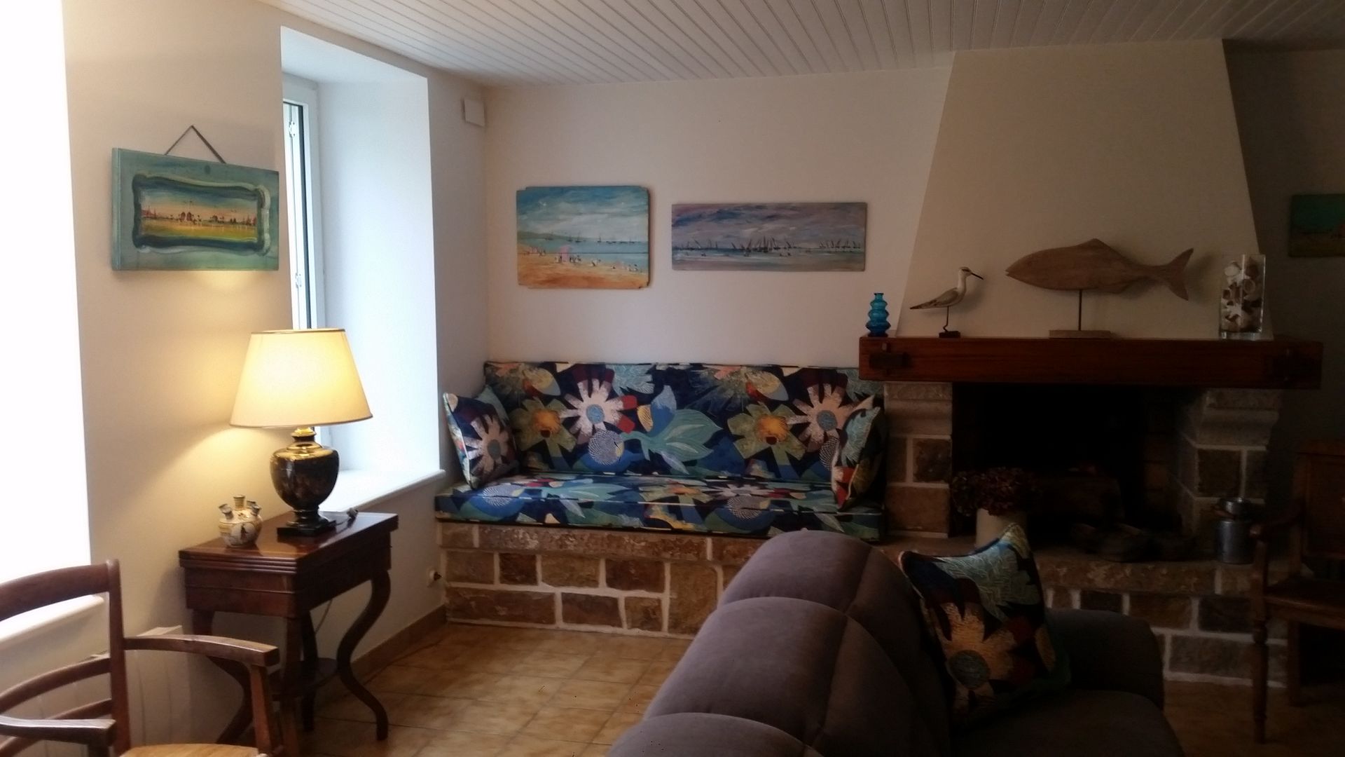 Salon avec cheminée, création d'une banquette avec coussins dans le même tissu.