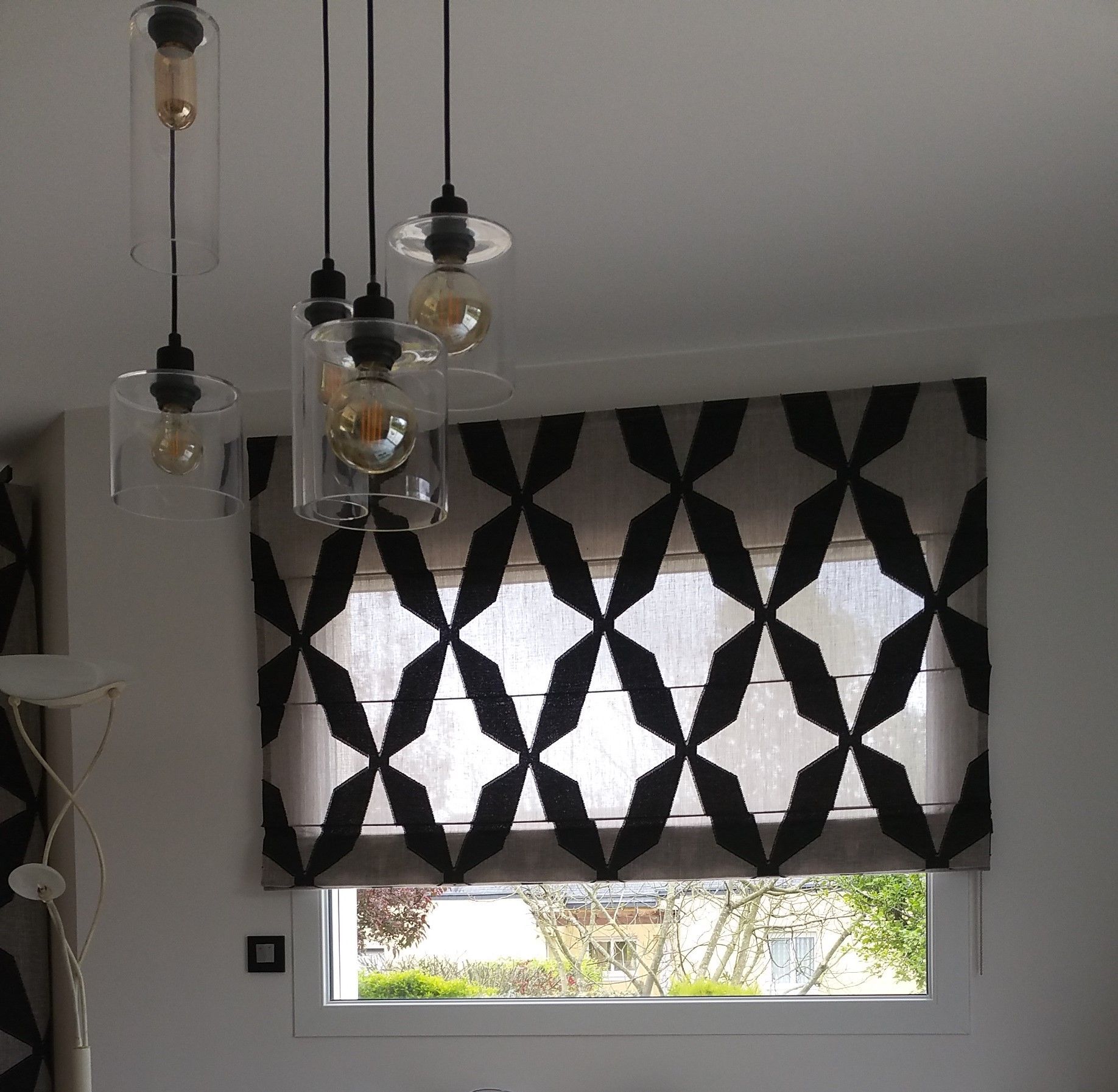 Fenêtres avec store bateau motifs géométriques noirs et transparence