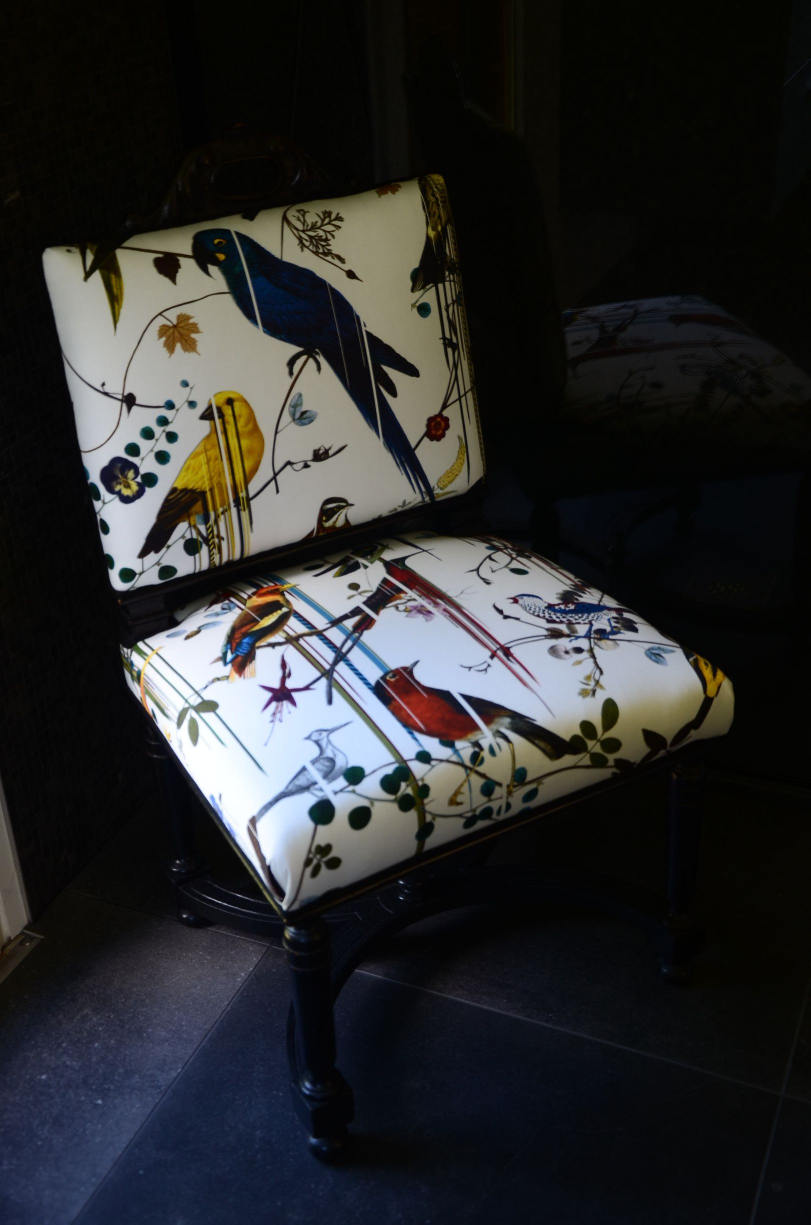 Chaise avec assise et dossier décorés d'un tissu blanc avec illustrations d'oiseaux et de plantes