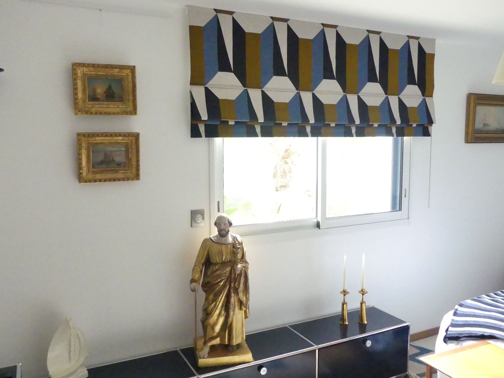 Fenêtre décorée d'un store bateau à motifs géométriques bleu et or 