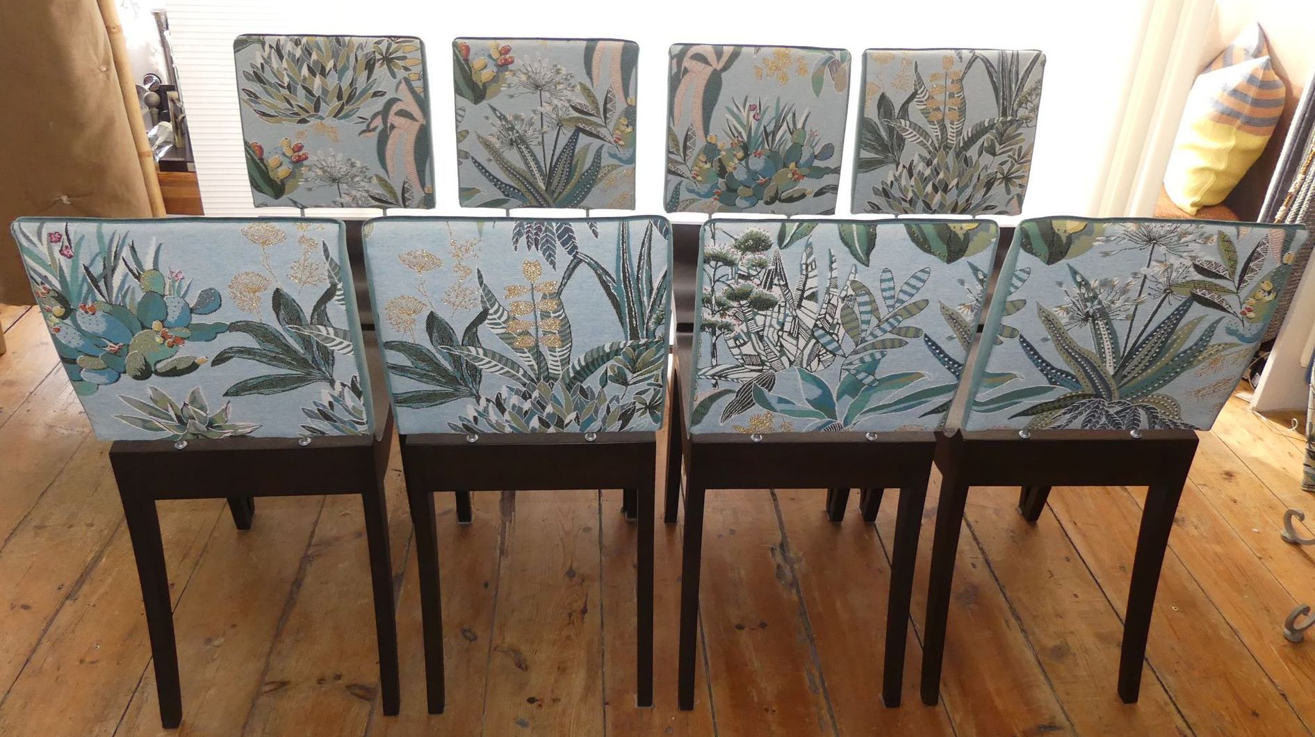 Chaises avec pieds et assises en bois, dossiers en tissu à motif fleuri avec des dégradés de gris et de bleu