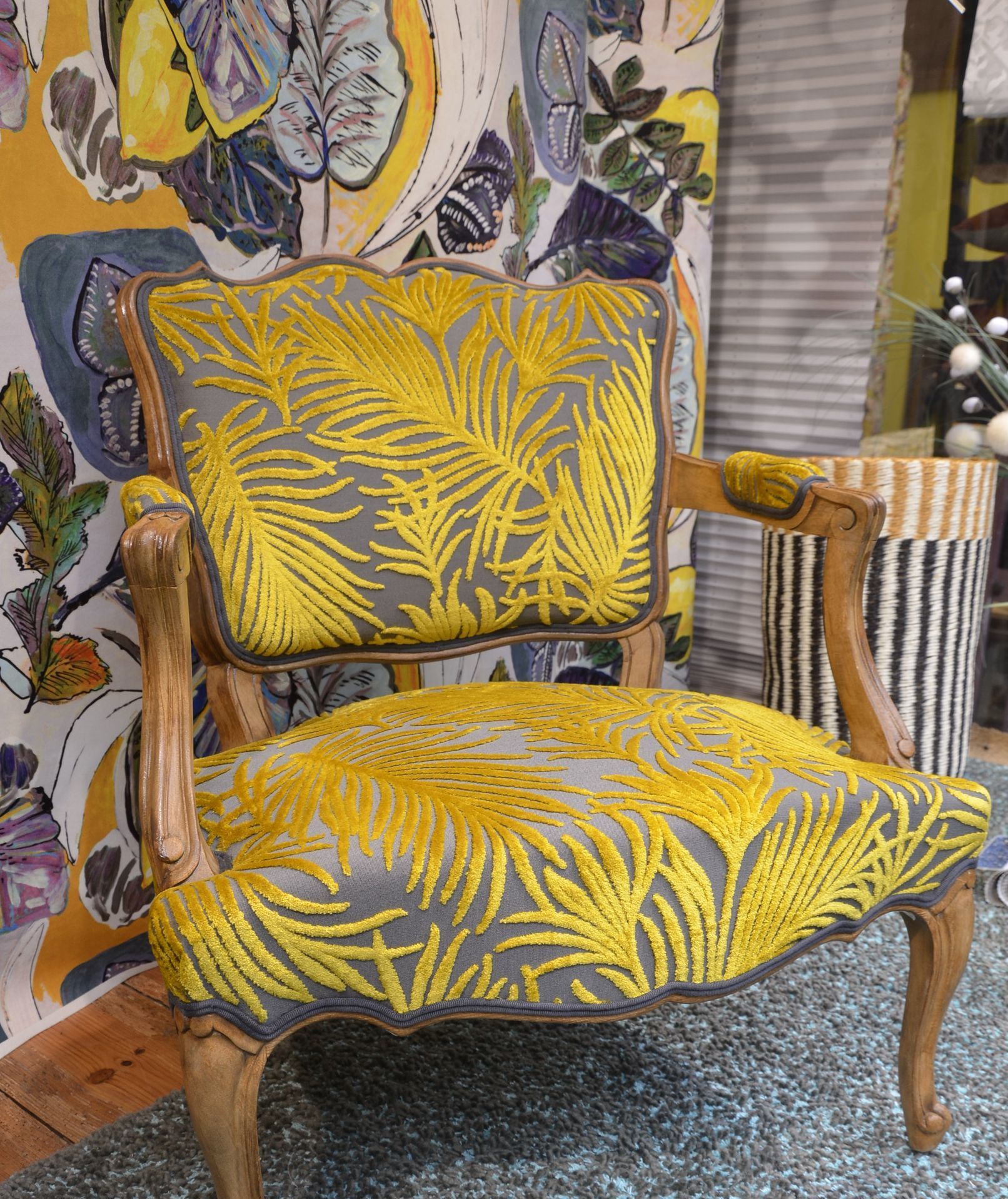 Fauteuil avec un tissu gris orné d'un relief en velours motif feuilles de fougères jaunes