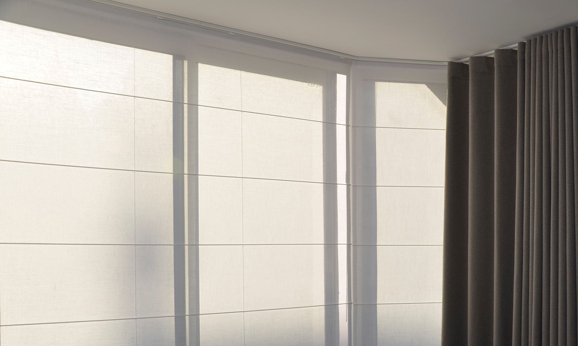 Baie vitrée avec stores bateaux blancs et rideaux wave de couleur grise