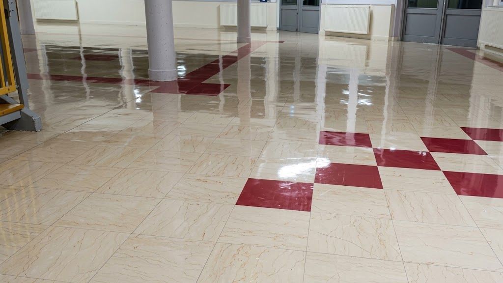Sol du hall carrelé brillant avec des incrustations géométriques rouges