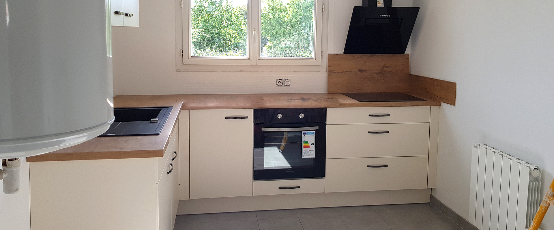 Pose d'une cuisine avec un plan de travail en bois et une façade blanche
