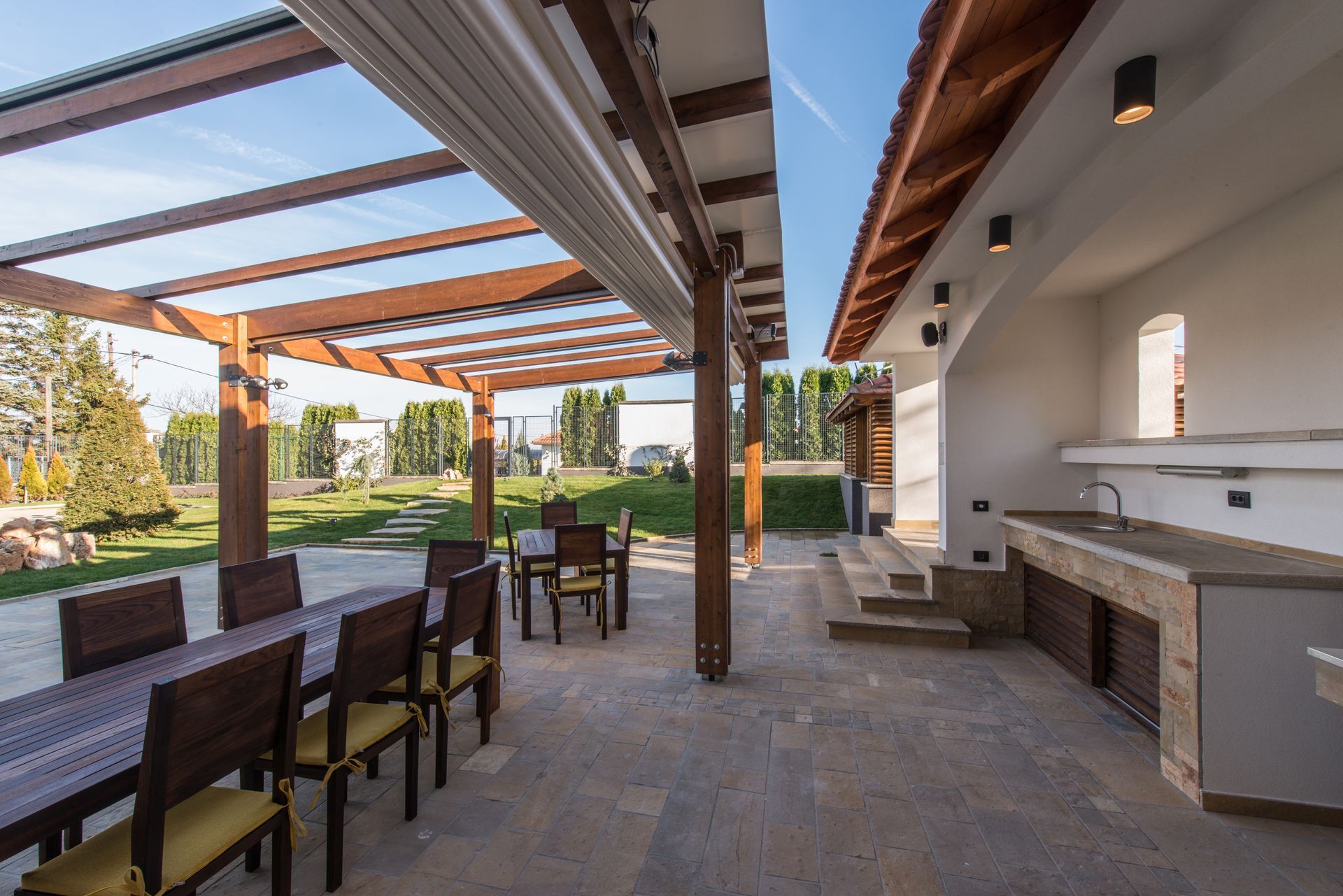 Une pergola en bois avec des stores qui se rabattent