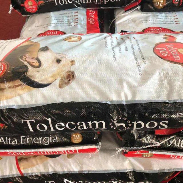 Varias bolsas de comida para perros Tolecam POS están apiladas una encima de otra.