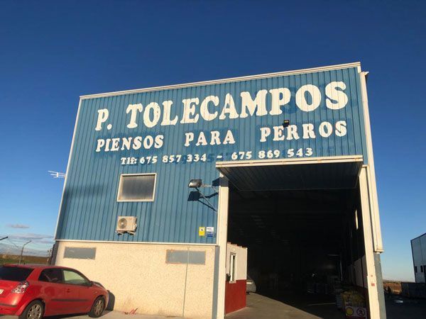 Un edificio azul con un cartel que dice p. tolecampos piensos para perros