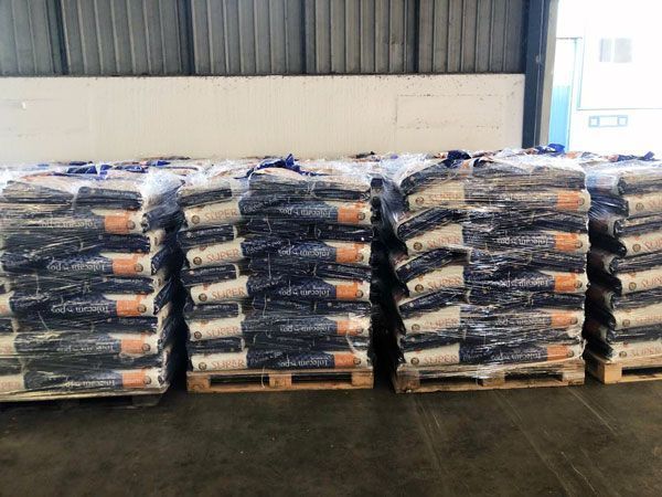 Un almacén lleno de pilas de bolsas y paletas.