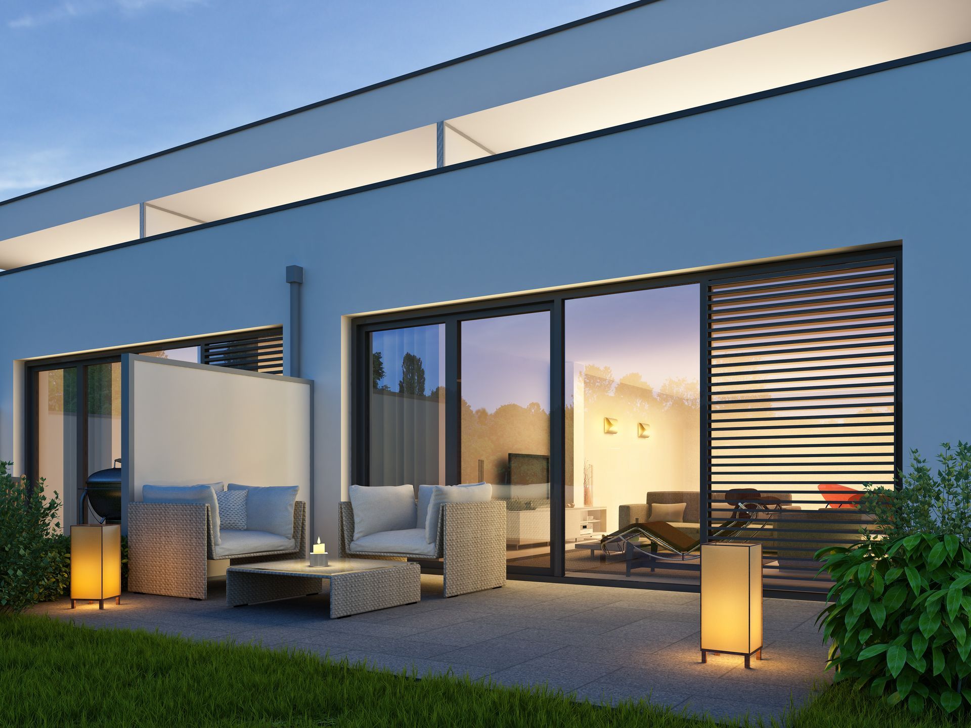 Patio moderne avec sièges extérieurs, guirlandes lumineuses et vue sur le coucher de soleil.