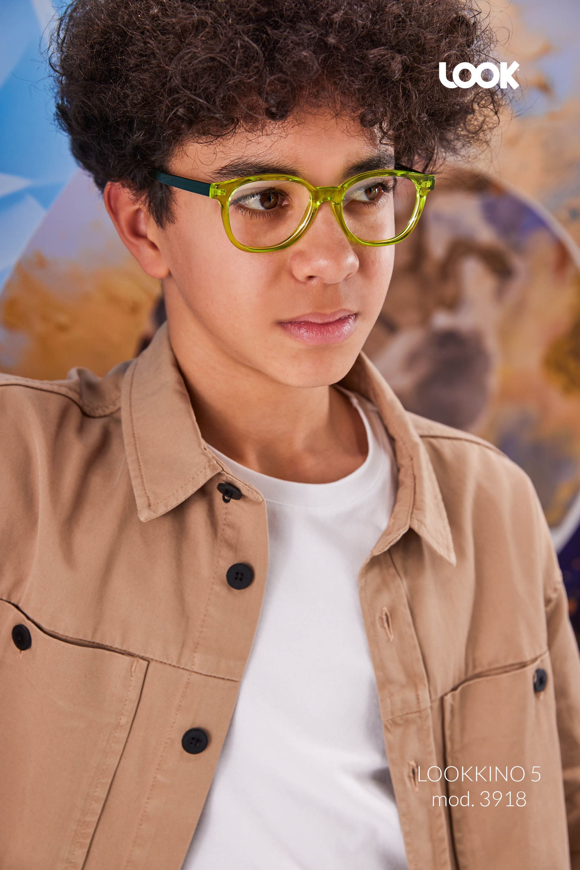 Un jeune garçon portant des lunettes et une chemise beige.