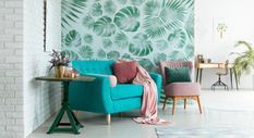 Una sala de estar con un sofá azul y una silla verde.