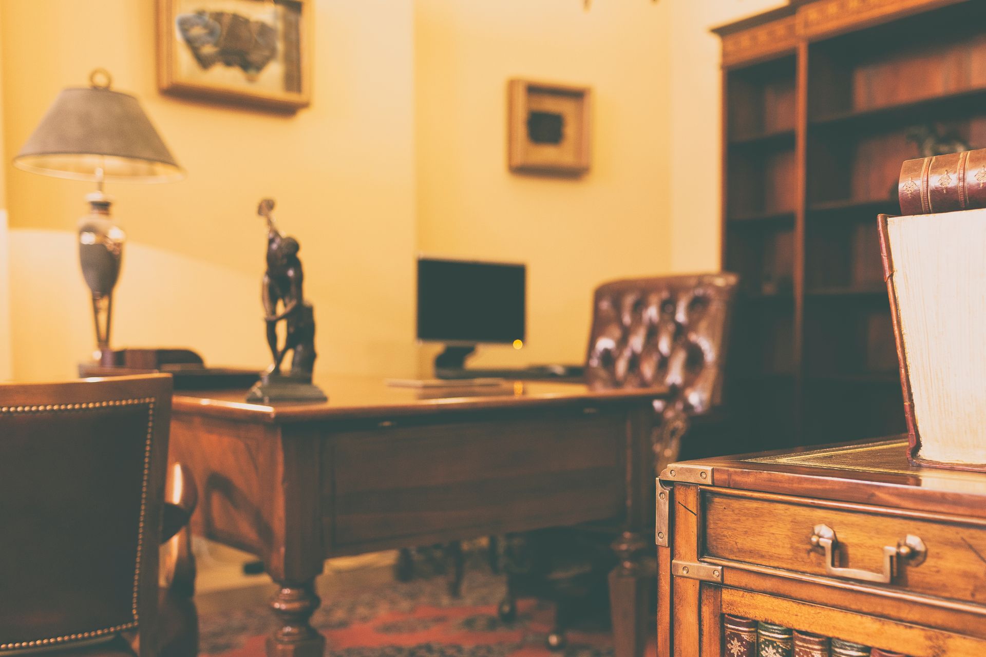 Bureau en bois vernis avec une statuette d'un lanceur de disque.