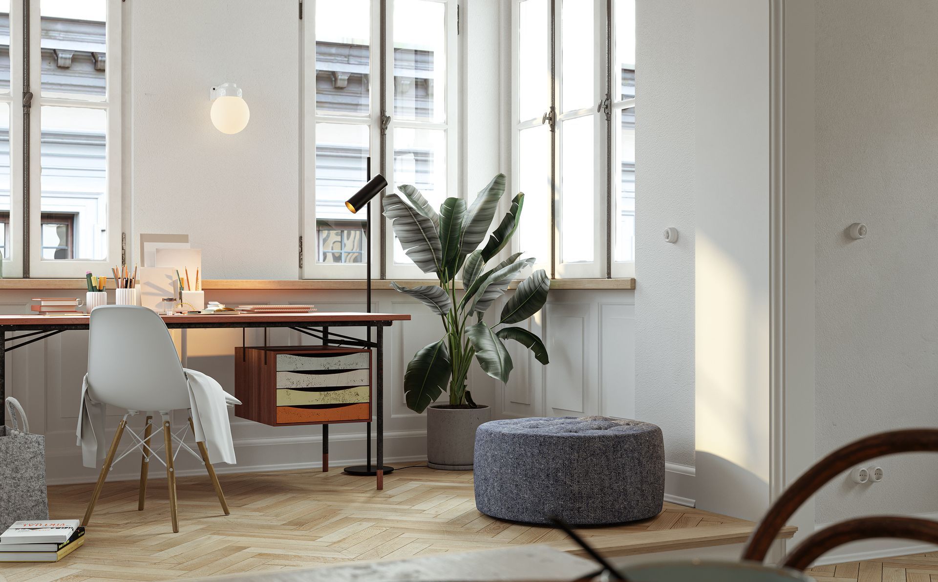 Pièce d'un appartement avec un petit bureau sous deux fenêtres.