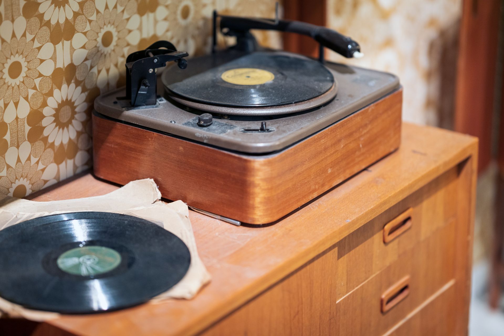Un vieux tourne-disque sur un meuble en bois.