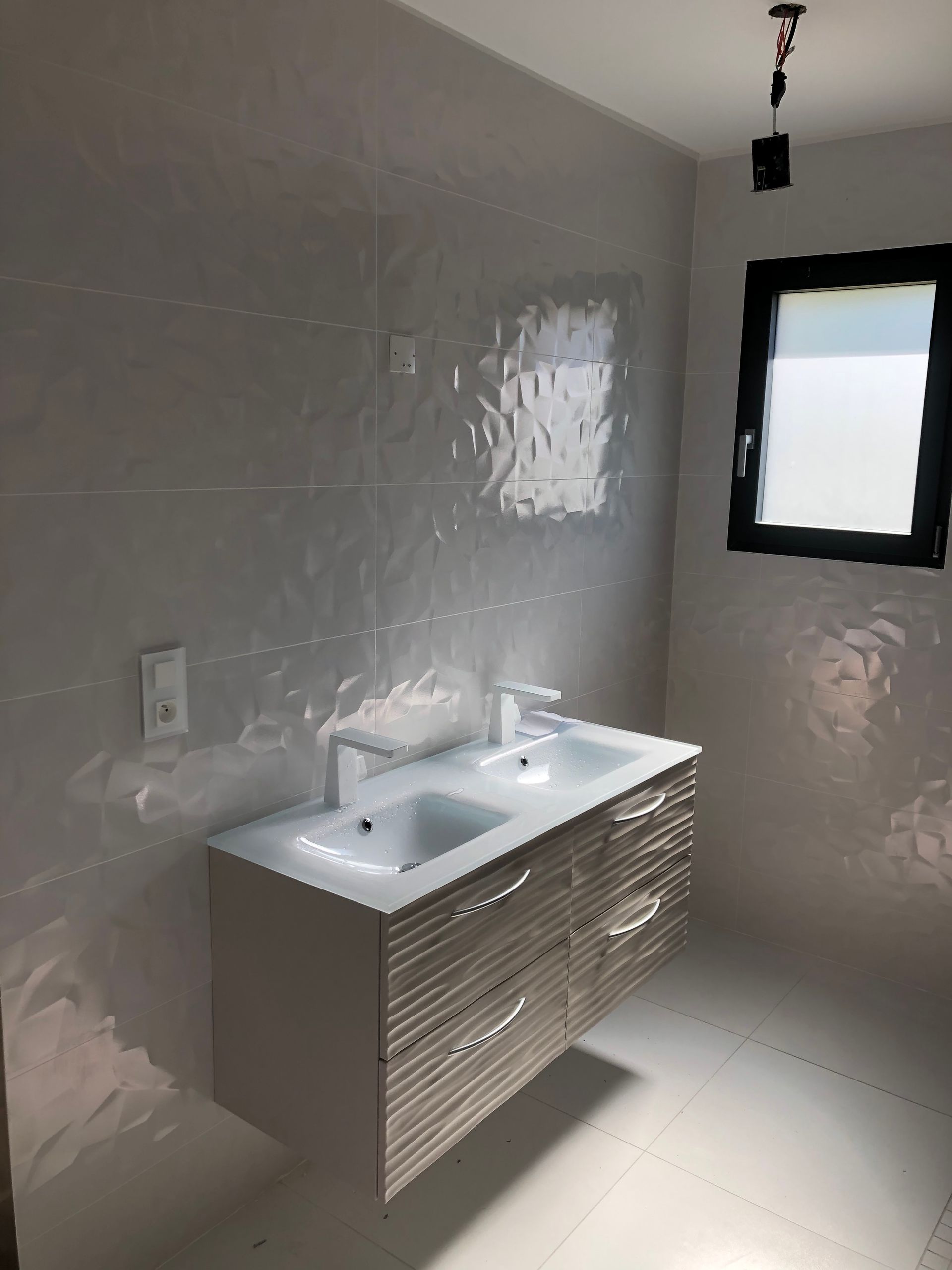 Photo de deux lavabos avec des murs gris