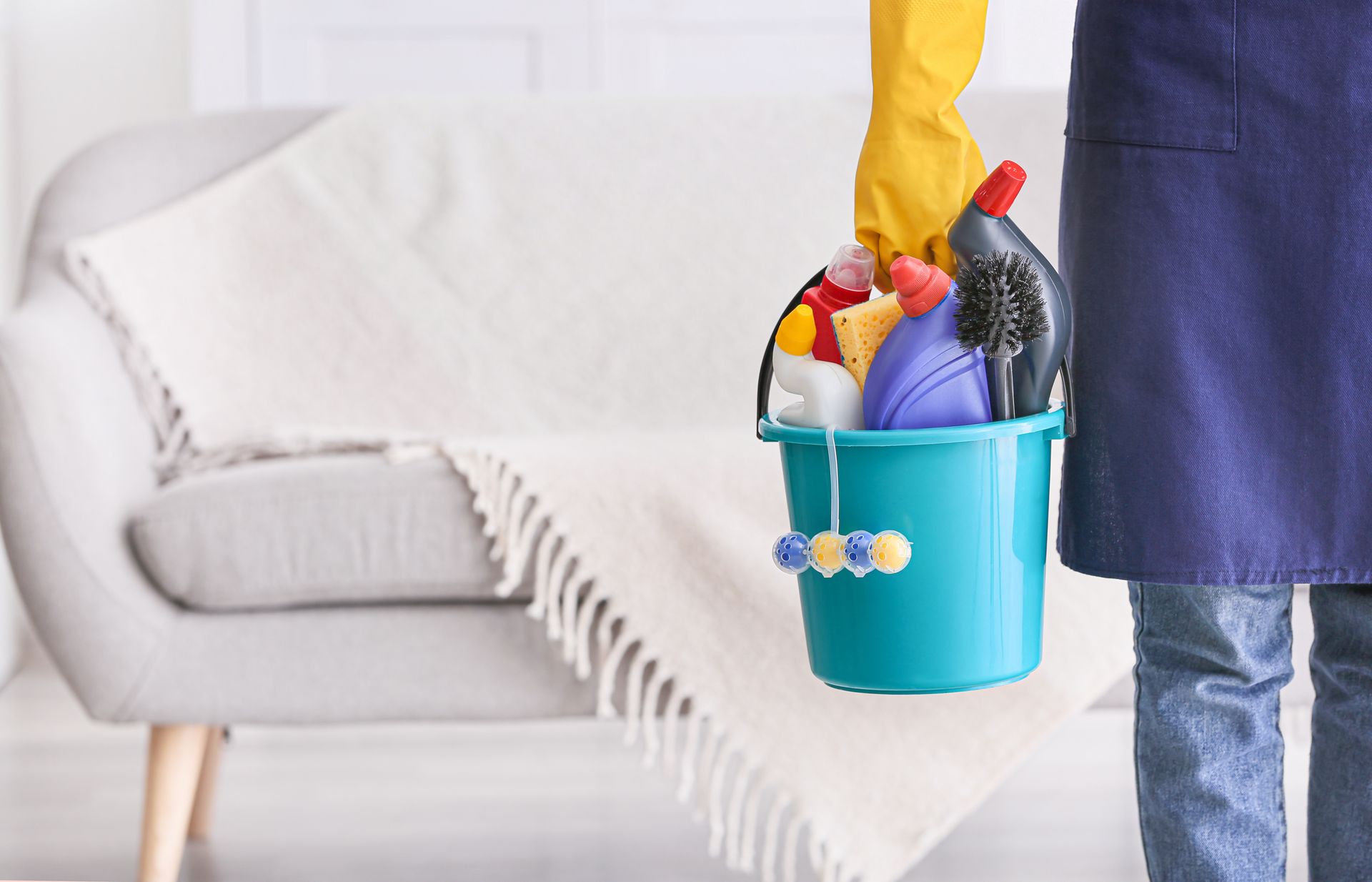 Homme tenant un sceau avec des produits d'entretien.