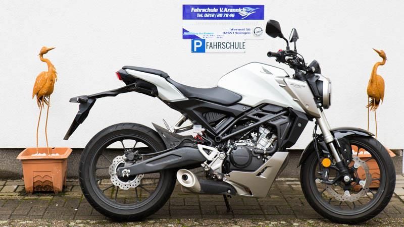 Ein weißes Honda-Motorrad steht vor einem Gebäude