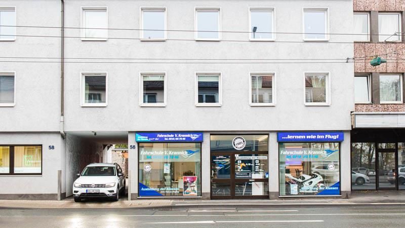 Ein weißes Auto steht vor einem Gebäude