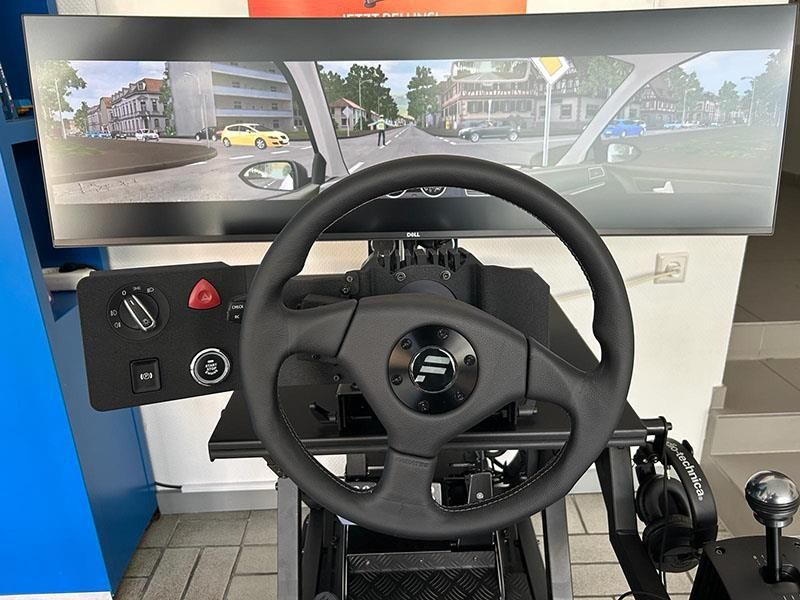 Ein Lenkrad auf einem Simulator mit einem Bildschirm dahinter