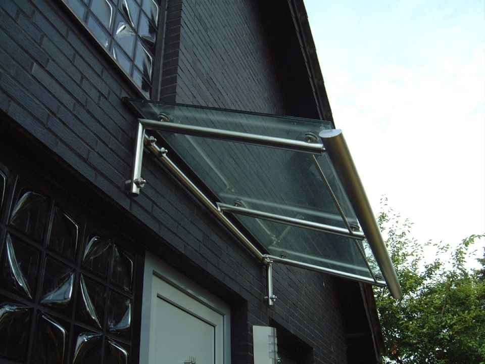 Ein schwarzes Backsteingebäude mit einem Glasdach über der Tür