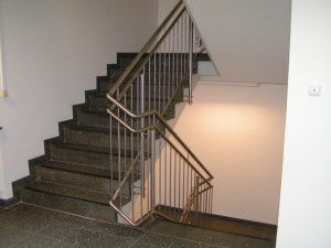 Eine Treppe mit einem Edelstahlgeländer in einem Gebäude.
