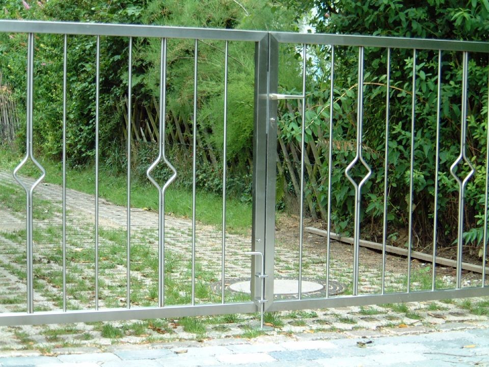 Ein Edelstahltor öffnet sich zu einer Einfahrt