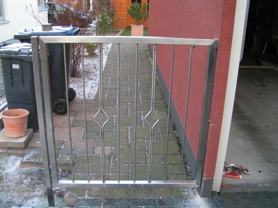 Ein Edelstahltor vor einem roten Gebäude