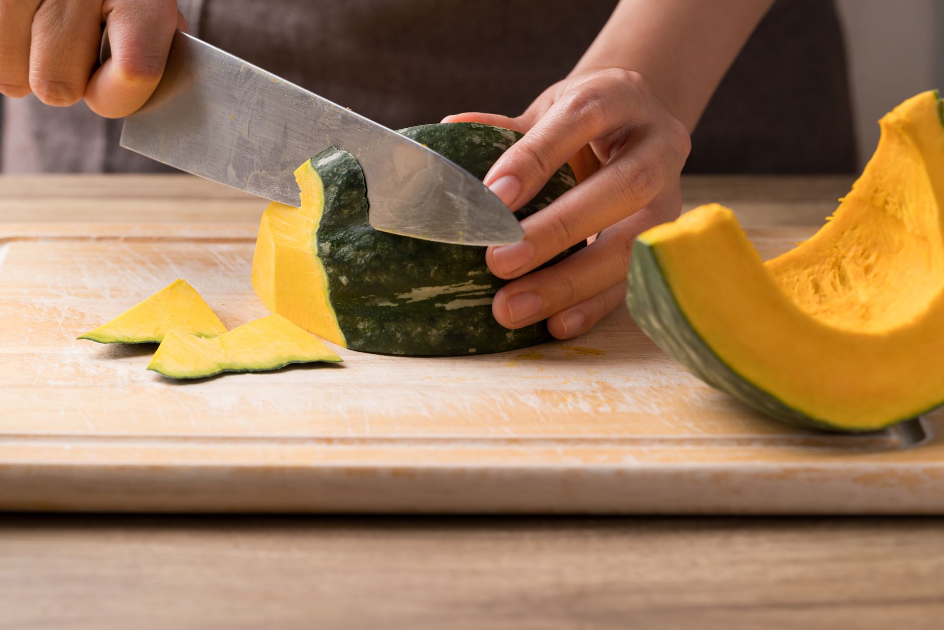 Une personne découpe une cucurbitacée